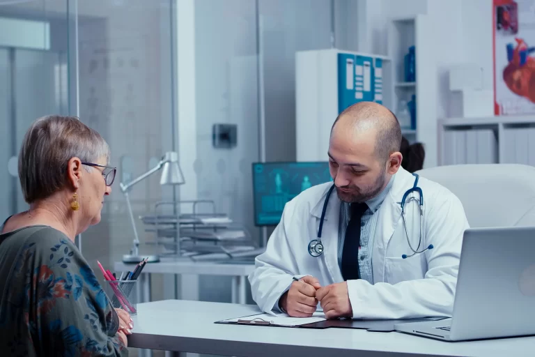 Doctor consulting with an elderly patient during a medical appointment, discussing heart health and treatment options